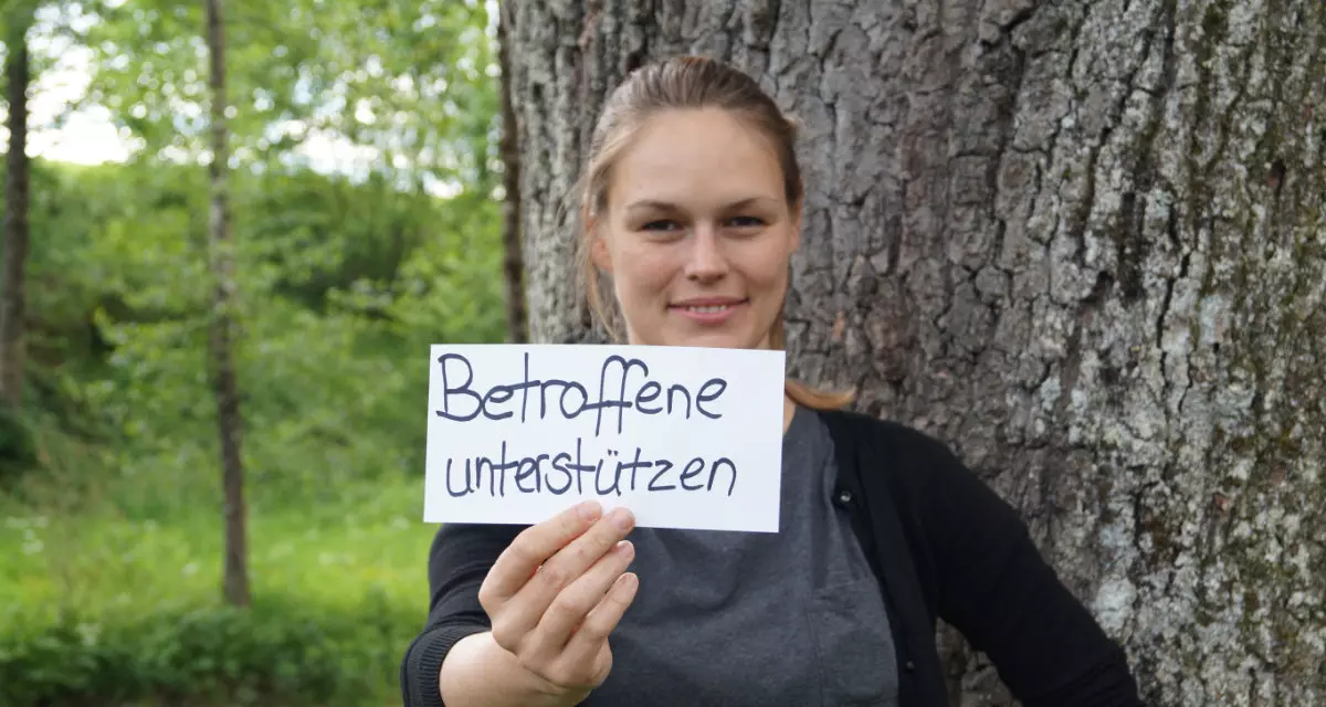 Teamerin beim Team meX mit Schild „Betroffene unterstützen“. Foto: Team meX