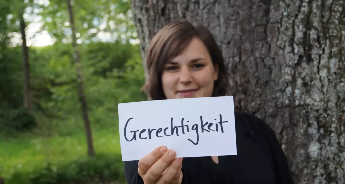 Teamerin beim Team meX mit Schild „Gerechtigkeit“. Foto: Team meX
