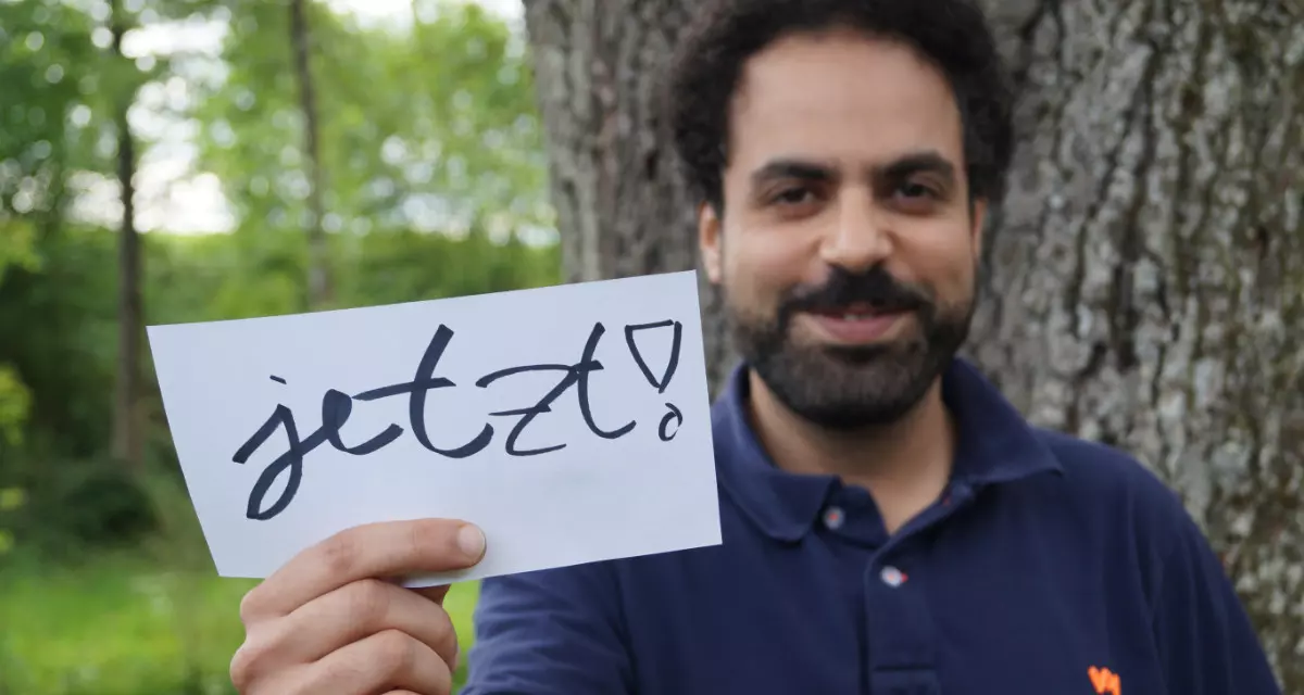 Teamer beim Team meX mit Schild „Jetzt!“. Foto: Team meX