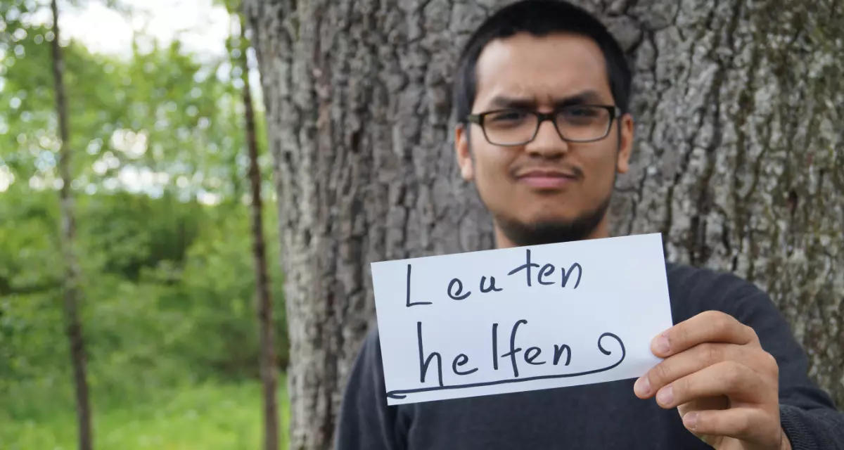 Teamer beim Team meX mit Schild „Leuten helfen“. Foto: Team meX